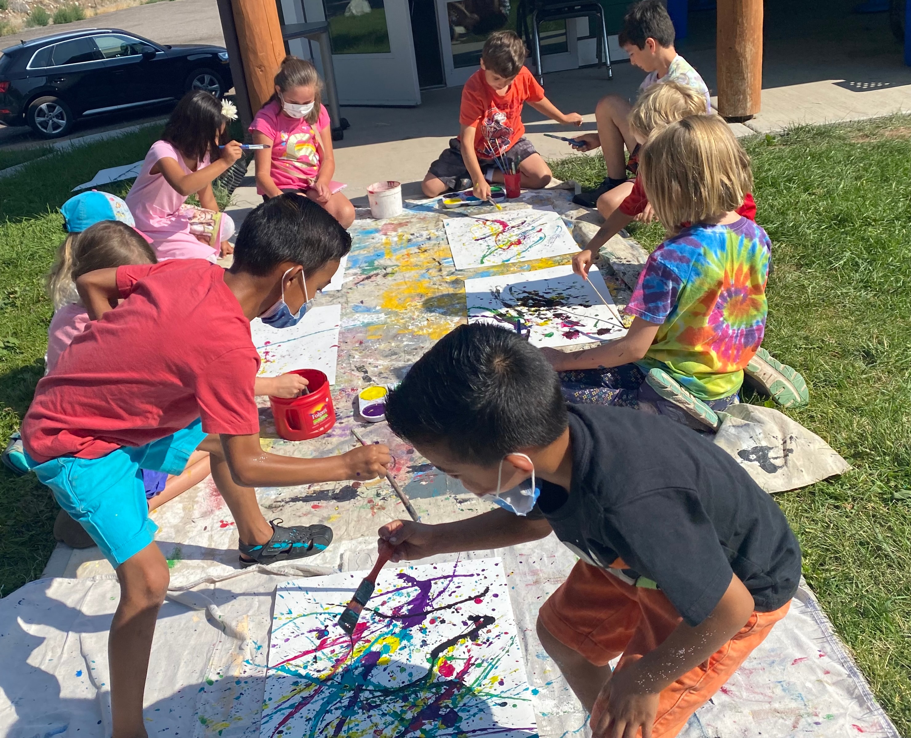Children doing splatter art at an outdoor market event