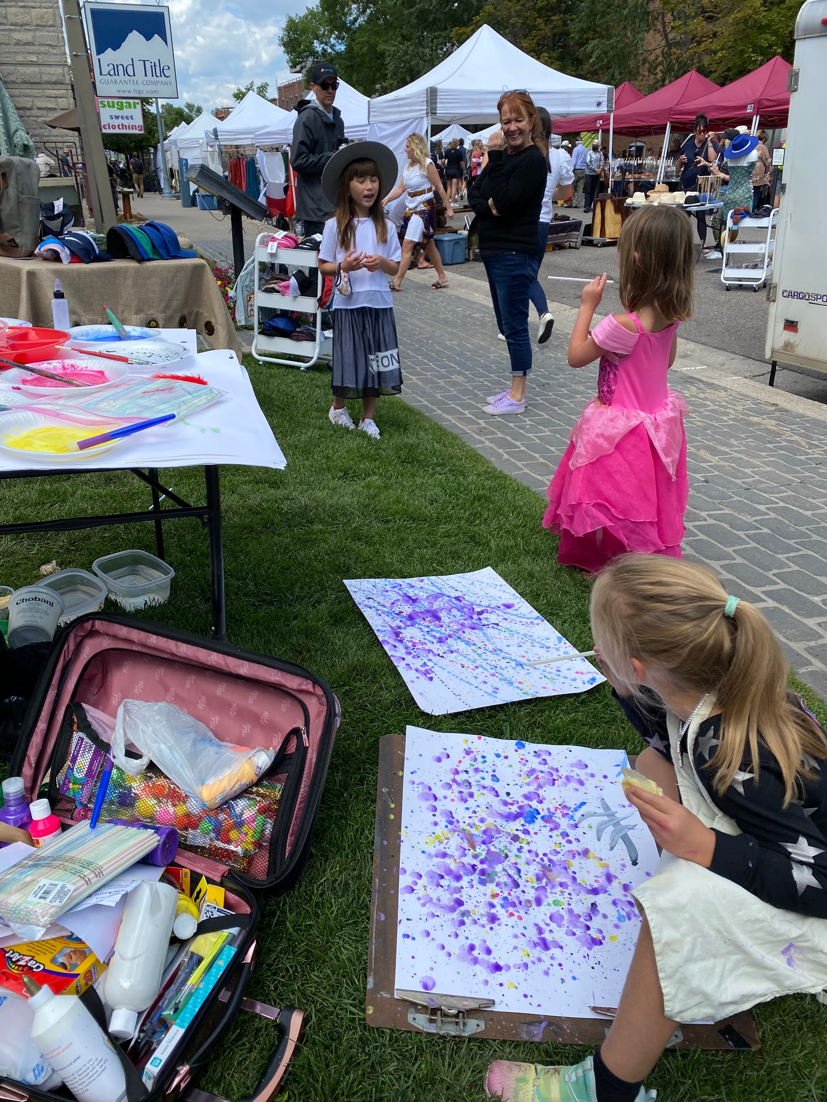 Children doing splatter painting outdoors at a Lea Art Studio kids class