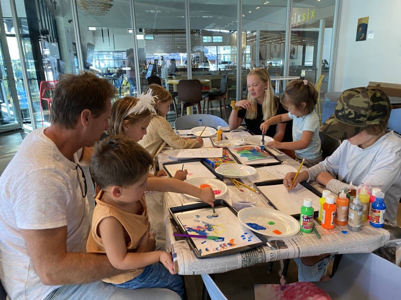 Two people holding a large bear painting at a Lea Art Studio class