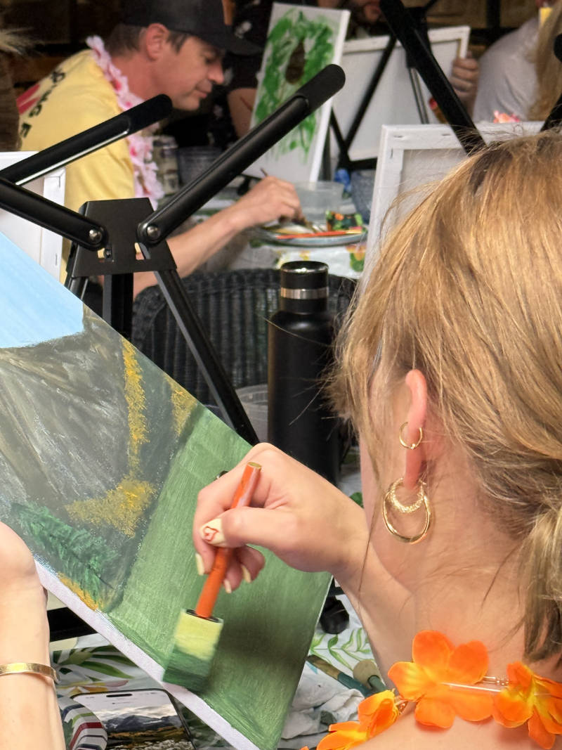 Adult students actively participating in a creative group painting workshop