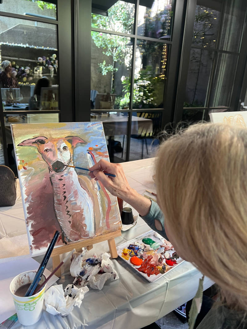 Adult student painting a dog portrait during a Paint Your Pet experience